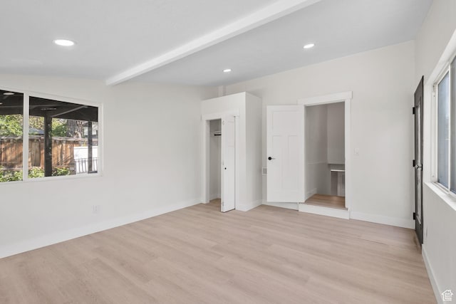 unfurnished bedroom featuring light wood finished floors, recessed lighting, baseboards, and beamed ceiling