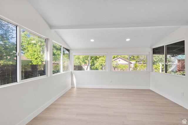unfurnished sunroom with vaulted ceiling, plenty of natural light, recessed lighting, wood finished floors, and baseboards