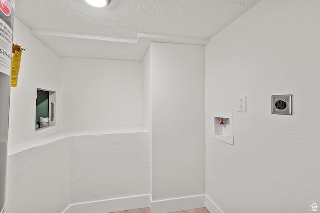 laundry room featuring hookup for a washing machine, hookup for an electric dryer, wood finished floors, a textured ceiling, and baseboards