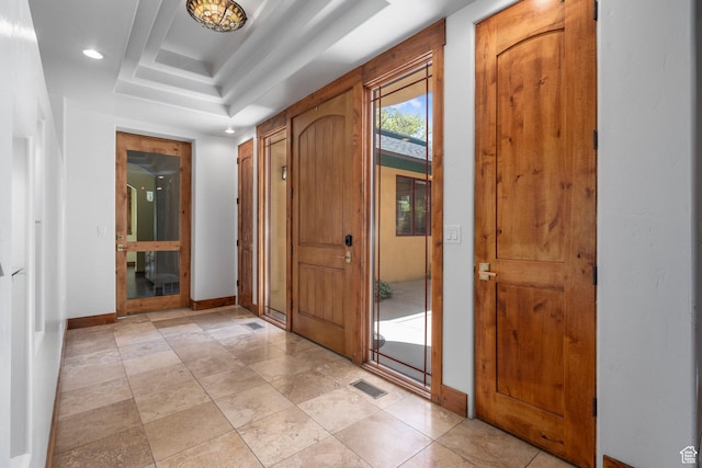 entryway featuring baseboards, recessed lighting, and a raised ceiling