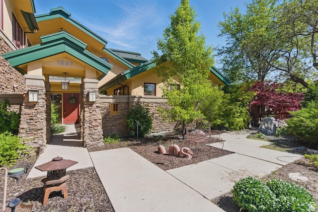 view of exterior entry featuring stone siding and stucco siding