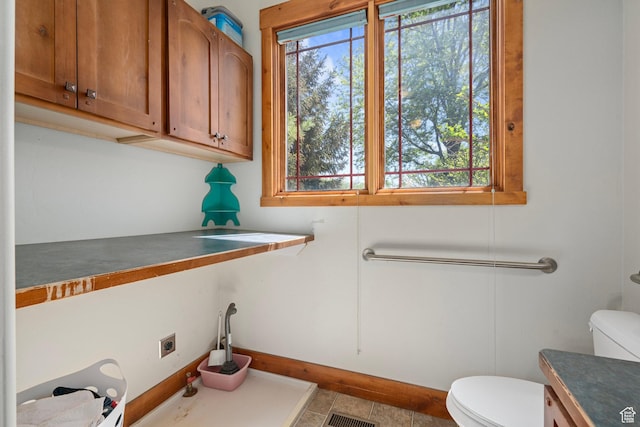 bathroom featuring toilet, baseboards, and vanity