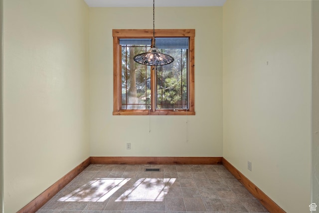 unfurnished dining area featuring baseboards