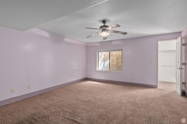 empty room with carpet flooring, ceiling fan, and baseboards