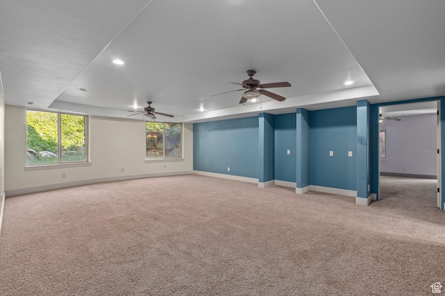 carpeted spare room featuring a ceiling fan, baseboards, a tray ceiling, and recessed lighting