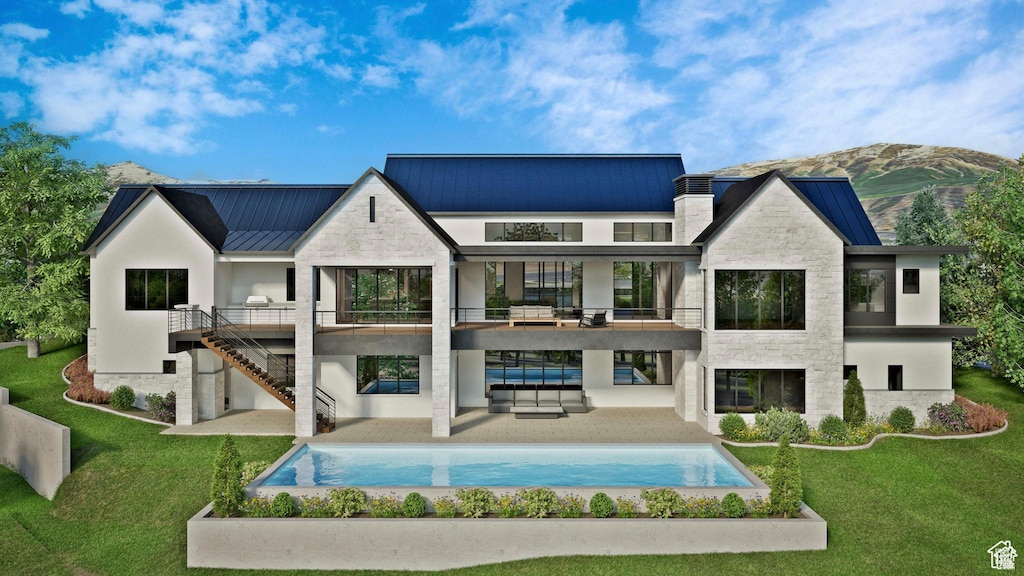 rear view of house with a balcony, a standing seam roof, a lawn, a patio, and metal roof