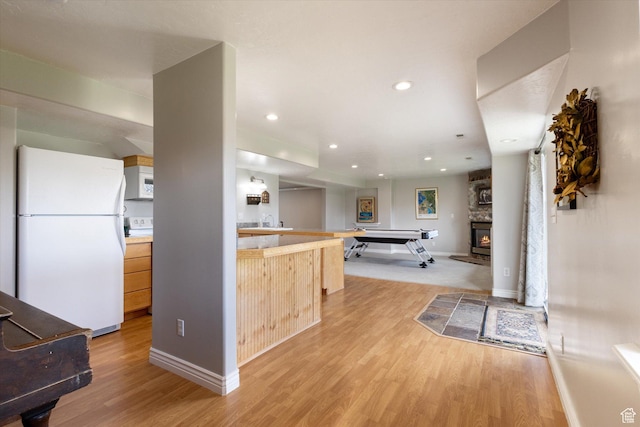 kitchen featuring white appliances, light wood-style flooring, light brown cabinetry, light countertops, and recessed lighting