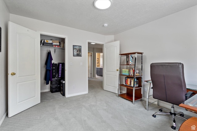 office space featuring carpet floors, baseboards, and a textured ceiling