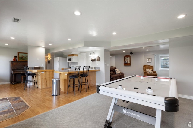 recreation room with recessed lighting, light wood-type flooring, and baseboards