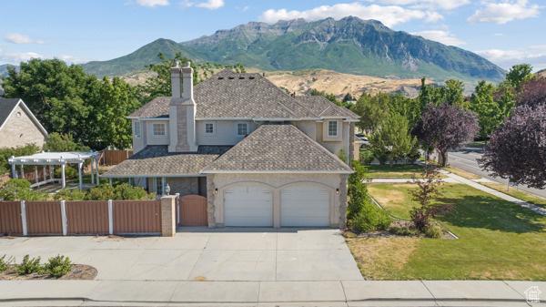 441 N Palisades Dr, Orem, UT 84097 - view of front of house featuring an attached garage, driveway, a chimney, and a mountain view