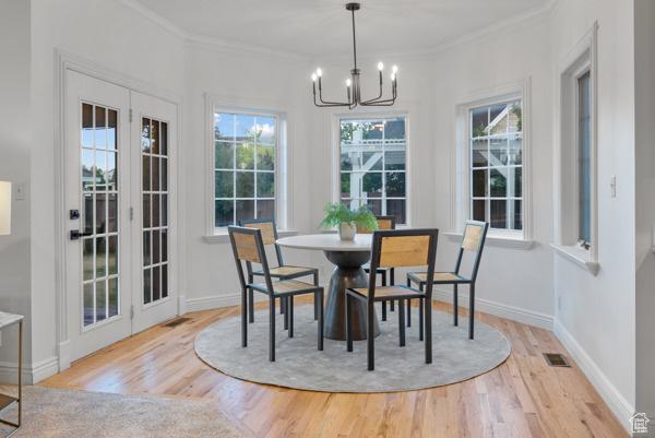 441 N Palisades Dr, Orem, UT 84097 - dining area with a chandelier, wood finished floors, plenty of natural light, ornamental molding, and french doors