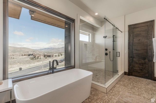 bathroom featuring a mountain view, a stall shower, a freestanding bath, and recessed lighting