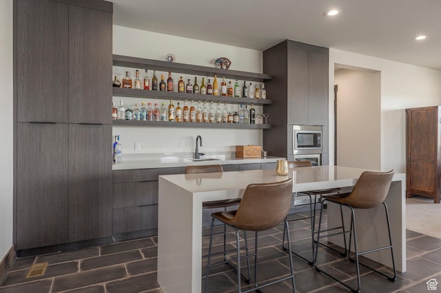 indoor wet bar with appliances with stainless steel finishes and recessed lighting