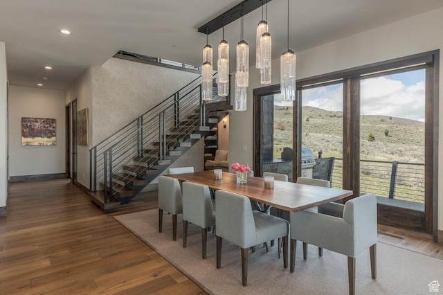 dining area featuring stairway, wood finished floors, recessed lighting, and a mountain view
