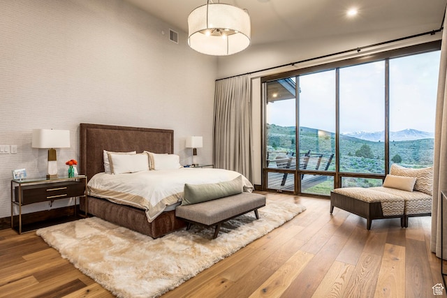 6110 E Blue Wing Loop, Kamas, UT 84036 - bedroom featuring hardwood / wood-style flooring, access to exterior, a mountain view, and a towering ceiling