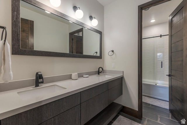 full bath with double vanity, enclosed tub / shower combo, recessed lighting, and baseboards