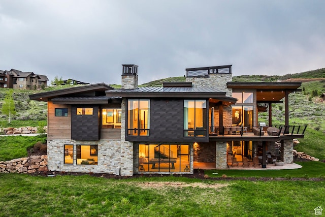 6110 E Blue Wing Loop, Kamas, UT 84036 - back of property with a chimney, a standing seam roof, stone siding, a lawn, and metal roof
