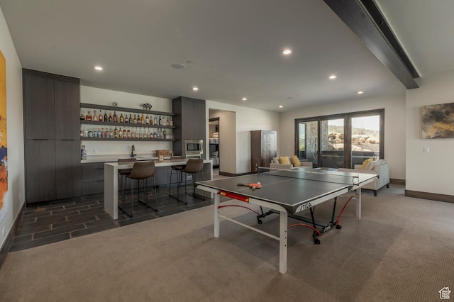 playroom with dark colored carpet, baseboards, bar, and recessed lighting