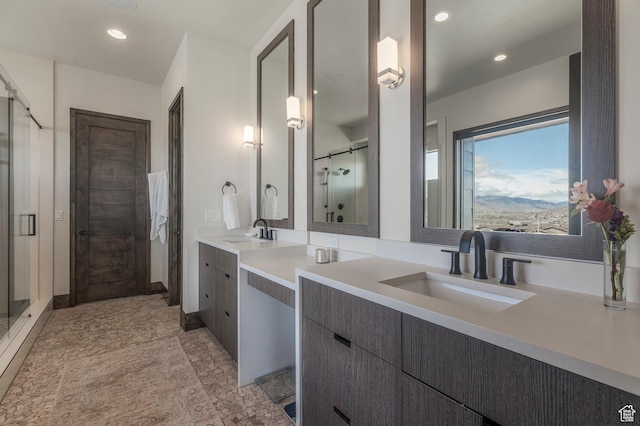 bathroom featuring double vanity, a stall shower, and recessed lighting