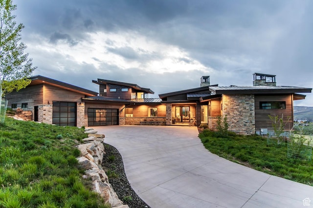 6110 E Blue Wing Loop, Kamas, UT 84036 - contemporary home featuring a standing seam roof, driveway, an attached garage, stone siding, and metal roof