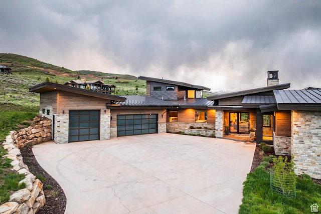 6110 E Blue Wing Loop, Kamas, UT 84036 - modern home featuring a standing seam roof, metal roof, a garage, stone siding, and concrete driveway
