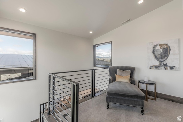 sitting room featuring an upstairs landing, recessed lighting, and carpet