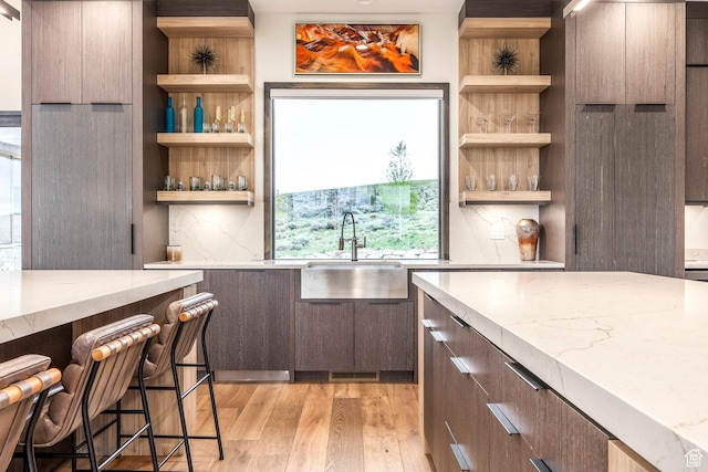 6110 E Blue Wing Loop, Kamas, UT 84036 - kitchen featuring a sink, open shelves, modern cabinets, light wood-style flooring, and backsplash