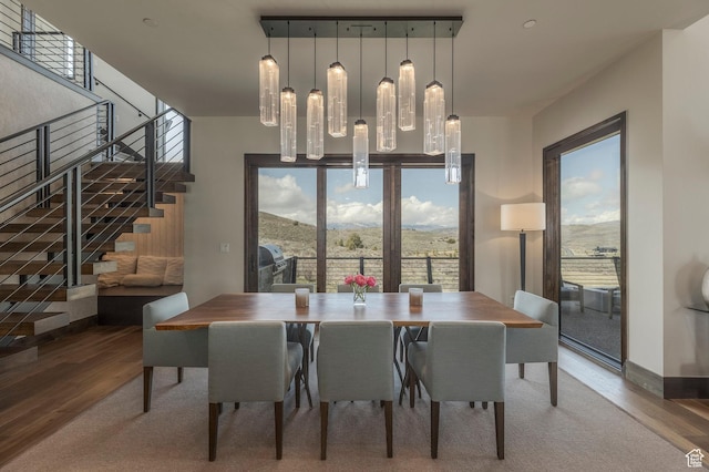 dining space with stairway, wood finished floors, and baseboards