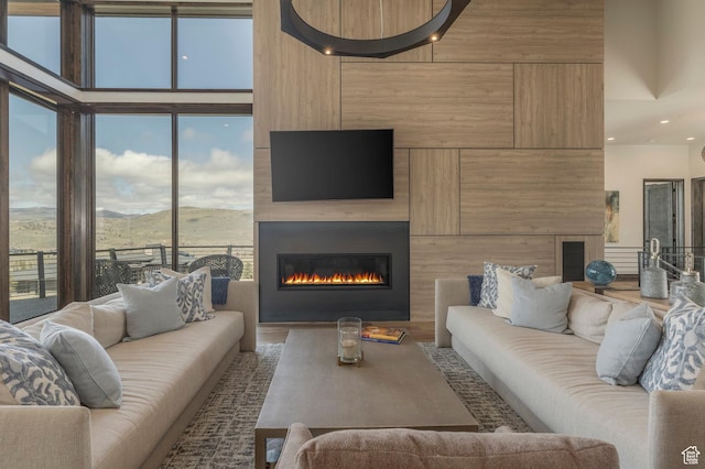 living room featuring a large fireplace, recessed lighting, and wood finished floors