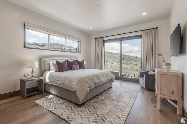 bedroom with access to exterior, light wood-style floors, and recessed lighting