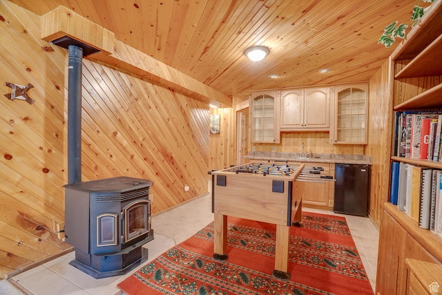 9174 Deer Creek Dr, Heber City, UT 84032 - recreation room with wood walls, a wood stove, wooden ceiling, light tile patterned flooring, and a sink