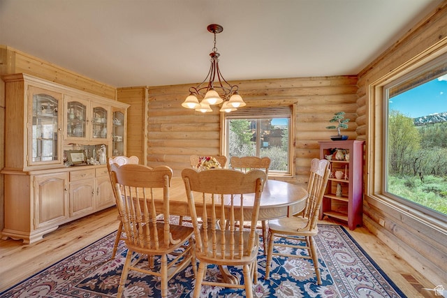 9174 Deer Creek Dr, Heber City, UT 84032 - dining room featuring log walls, light wood-style flooring, plenty of natural light, and a chandelier