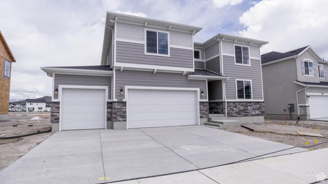 5488 N Trailside Unit 431, Eagle Mountain, UT 84005 - view of front of house featuring stone siding, a garage, and driveway