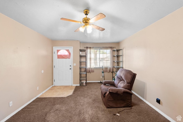 sitting room featuring carpet, a ceiling fan, and baseboards