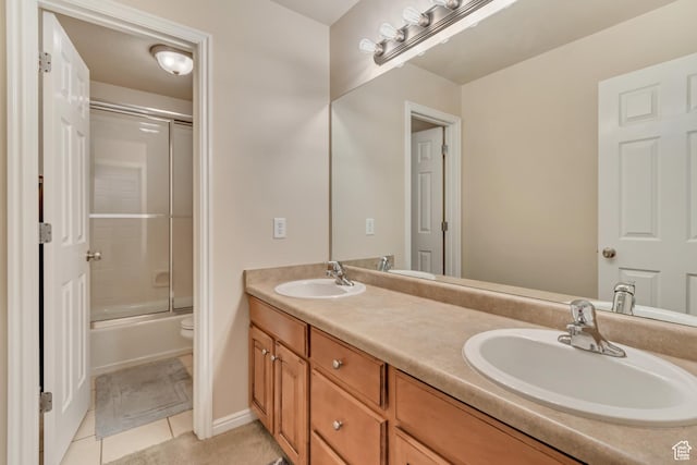 full bath featuring tile patterned floors, double vanity, toilet, and combined bath / shower with glass door