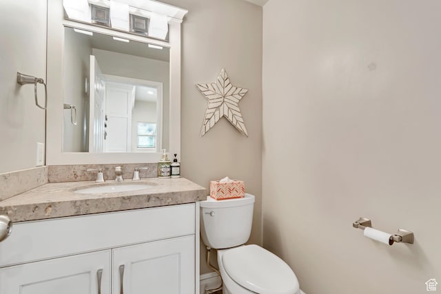 half bathroom with toilet and vanity
