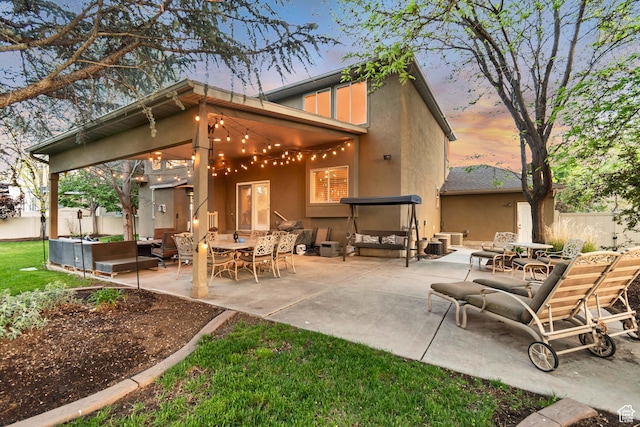 back of house with stucco siding, outdoor lounge area, a patio area, and fence