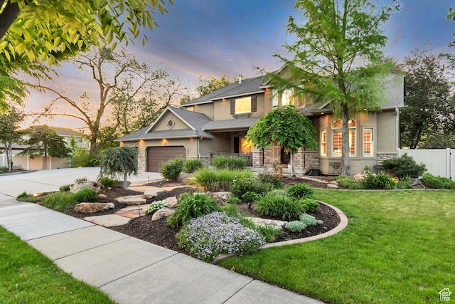 view of front of home featuring stucco siding, stone siding, driveway, and a garage