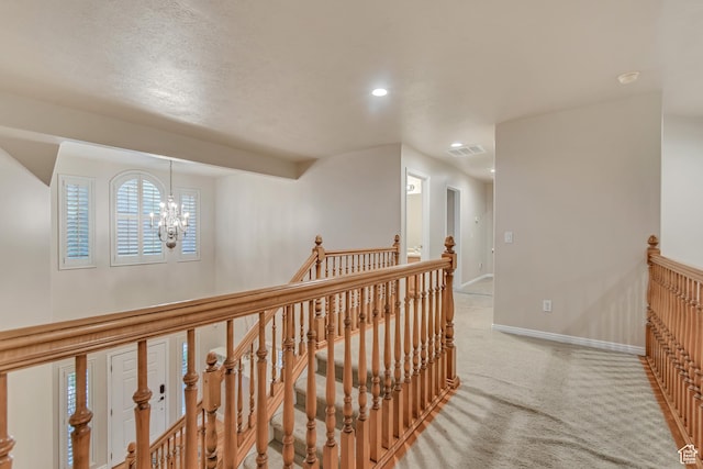 hallway with an upstairs landing, light carpet, baseboards, a chandelier, and recessed lighting
