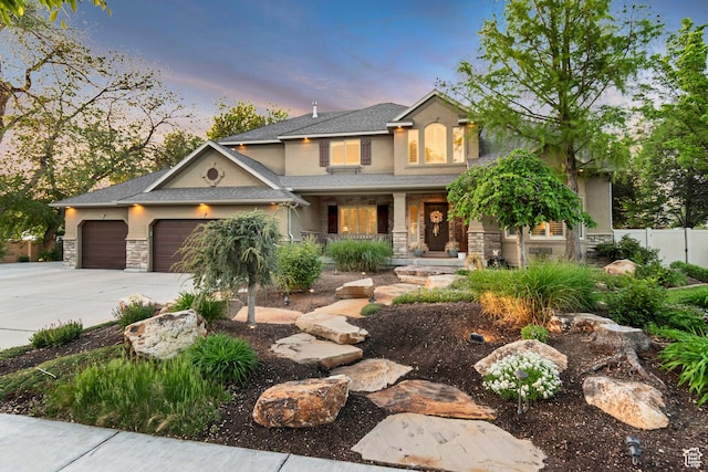 view of front of property with covered porch, stone siding, stucco siding, fence, and concrete driveway