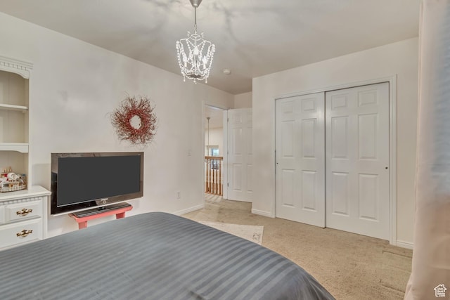 bedroom with a chandelier, light carpet, a closet, and baseboards