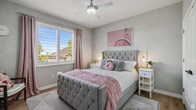 bedroom featuring wood finished floors, baseboards, and a ceiling fan