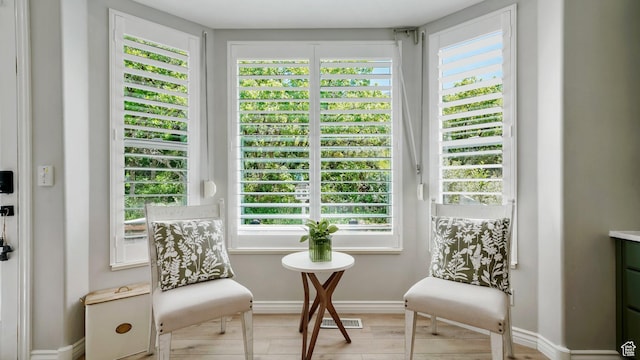 sitting room with healthy amount of natural light, baseboards, and wood finished floors
