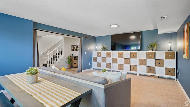 carpeted living area with stairway, baseboards, and a textured ceiling