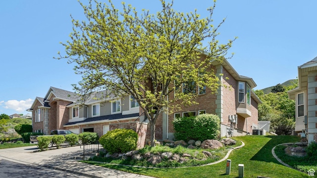 view of property exterior with brick siding and a yard
