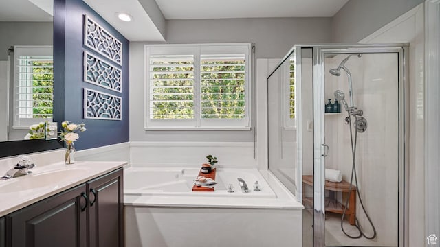 bathroom with a shower stall, a garden tub, vanity, and recessed lighting