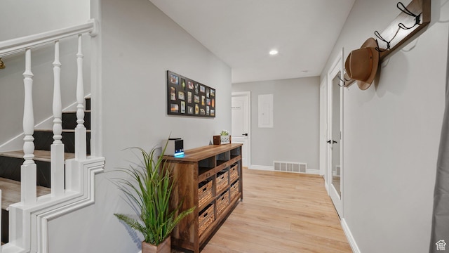 corridor with light wood-style flooring, recessed lighting, stairs, and baseboards