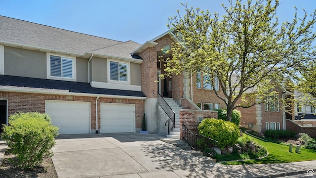 townhome / multi-family property with driveway, stucco siding, stairs, a garage, and a shingled roof