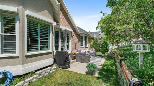 view of side of property with brick siding, a patio area, stucco siding, and an outdoor hangout area
