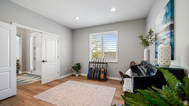 sitting room featuring light wood-style floors, baseboards, and recessed lighting